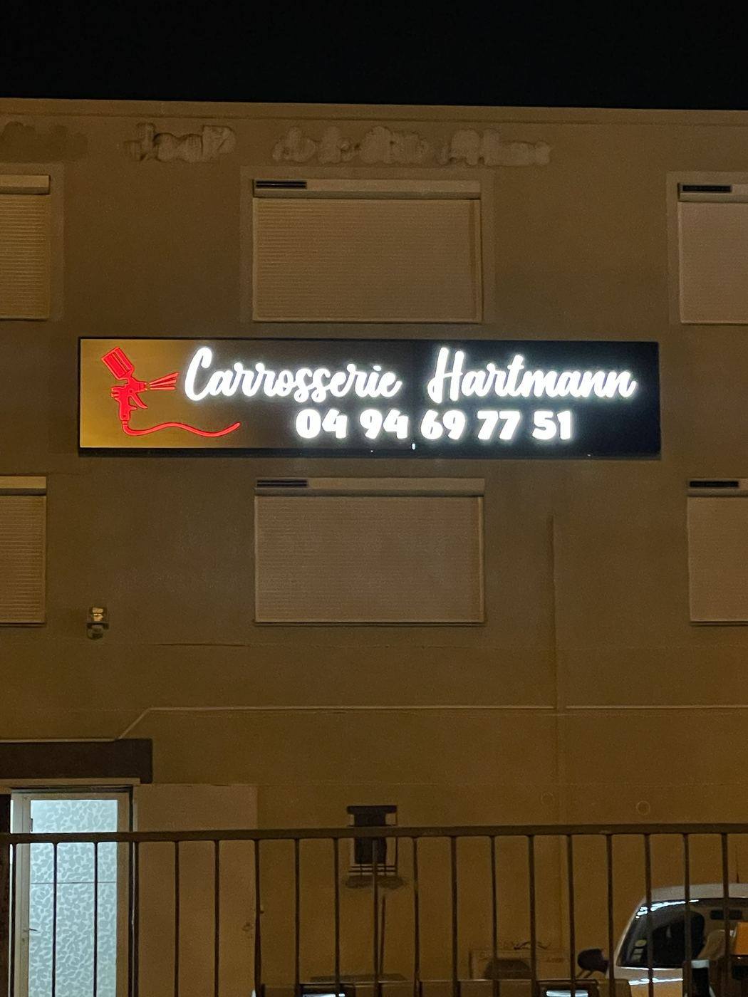 Enseigne lumineuse Carrosserie Hartmann de nuit